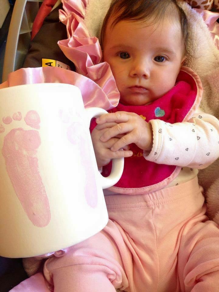 Adorable Baby Holding a Footprinted Mug