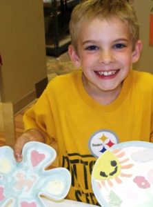 Smiling Happy Boy Holding Painted Pottery Plates