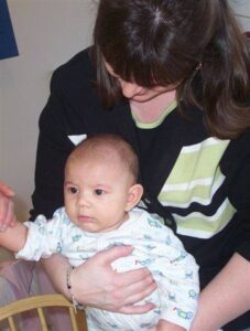 Baby getting handprinted on pottery at Claytopia